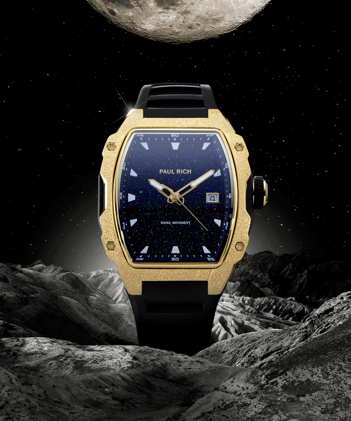 Paul Rich tonneau-shaped watch with blue aventurine dial and gold frosted bezel displayed against moonlit space and rocky lunar terrain.