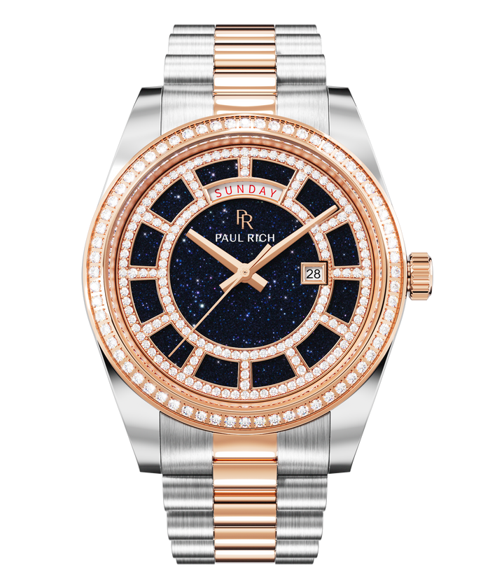Two-tone silver and rose-gold watch with a blue aventurine dial, day and date windows, and a bezel and hour markers set with crystal stones.