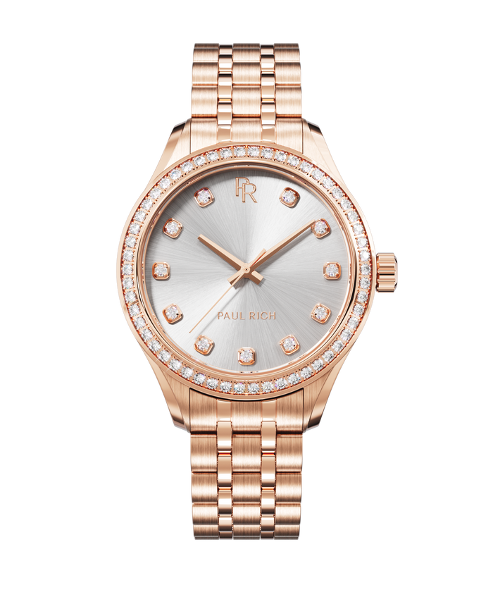 Front view of a rose gold wristwatch with a silver sunray dial, diamond-set hour markers, gem-set bezel, and a rose gold jubilee bracelet.