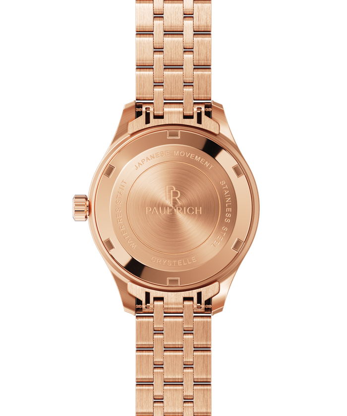 Back view of a rose gold wristwatch showing an engraved caseback with “Paul Rich,” “Japanese Movement,” “Stainless Steel,” and “Crystelle.”