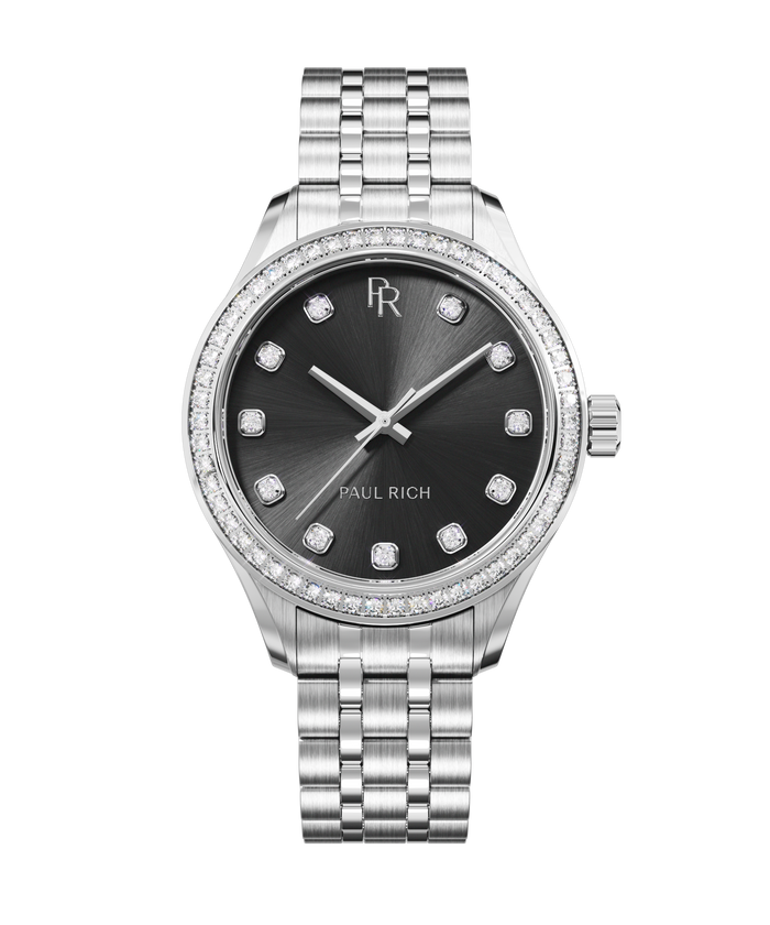 Front view of a silver-tone Paul Rich watch with a black sunray dial, diamond hour markers, gem-set bezel, and silver jubilee bracelet.