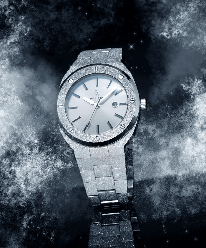Paul Rich frosted silver watch with metallic dial and date window, shown at an angle against a cosmic background of stars and mist.